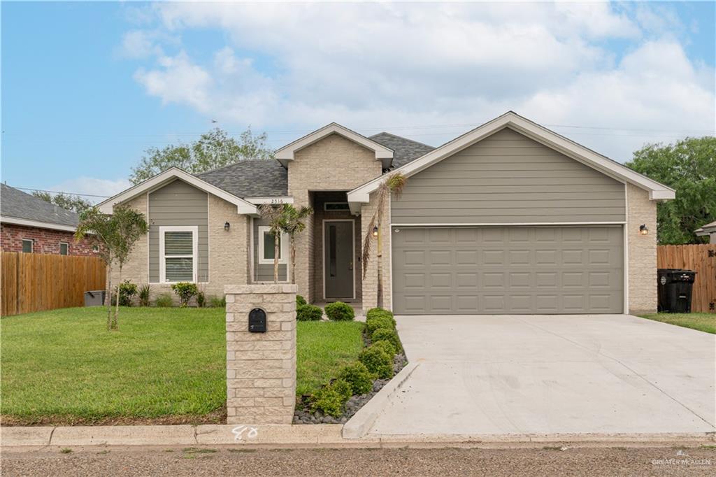 View of front of property with a garage and a front lawn