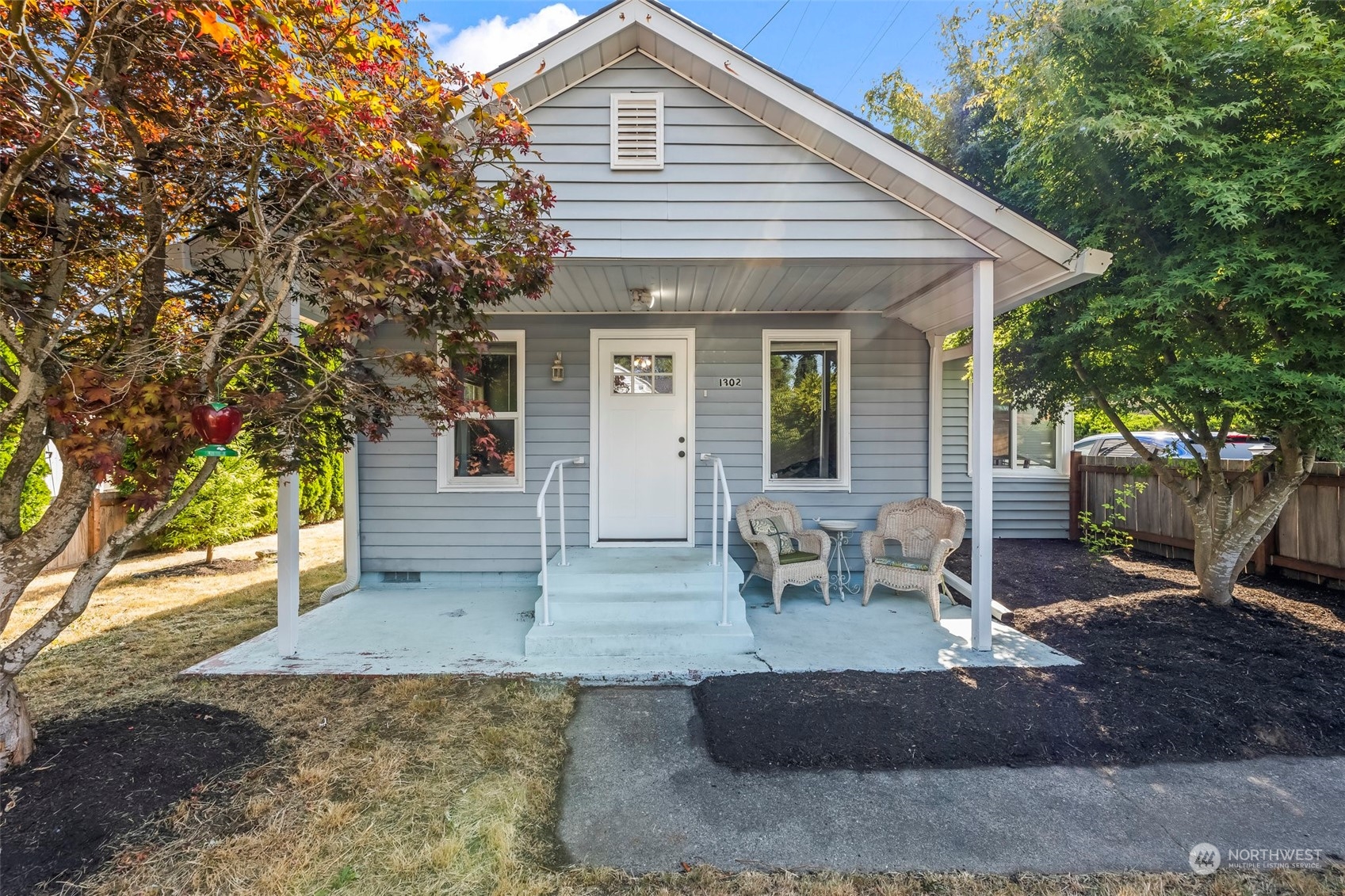 a view of a house with backyard and sitting area