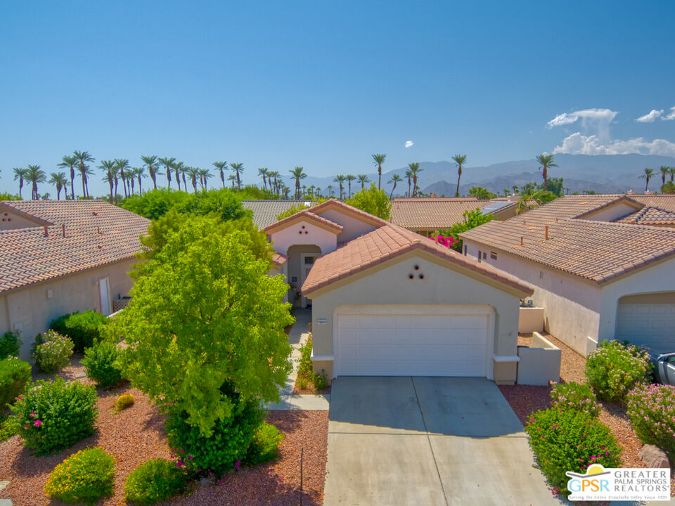 a aerial view of a house with a yard and potted plants