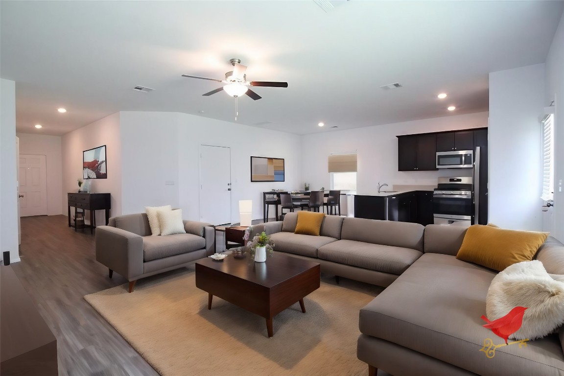 a living room with furniture kitchen view and a chandelier