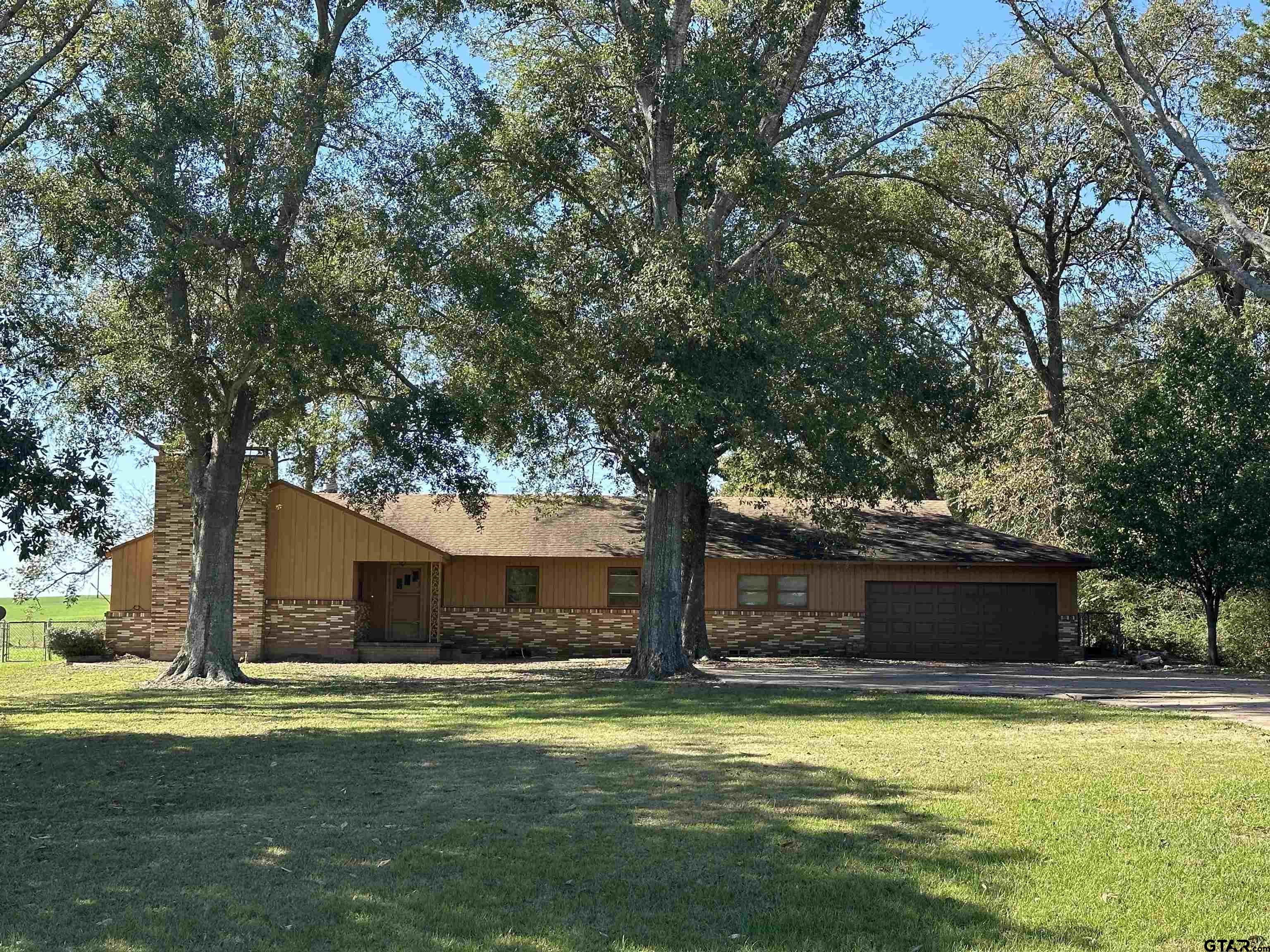 a front view of a house with a yard and trees