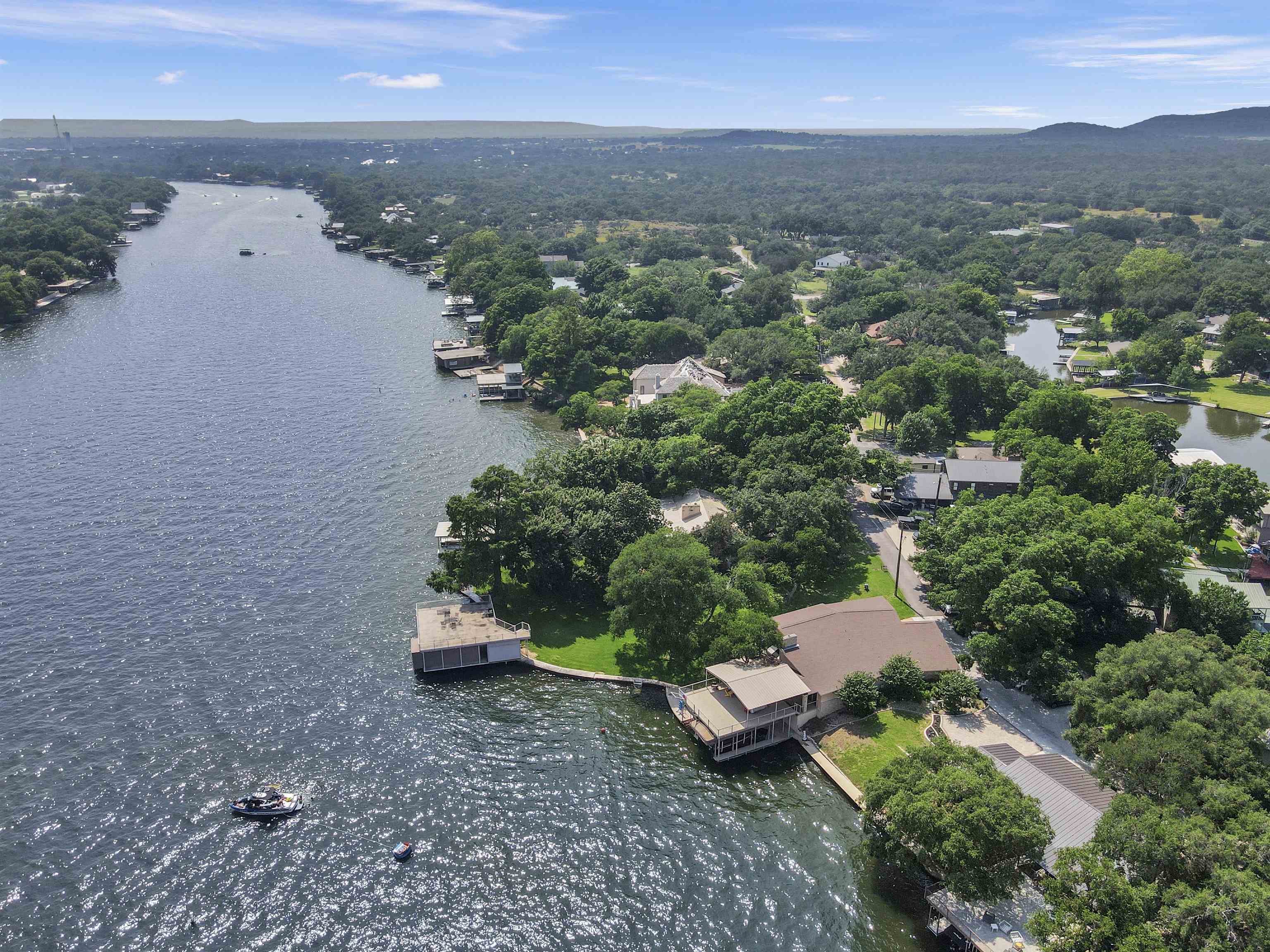 an aerial view of a house with a yard and lake view