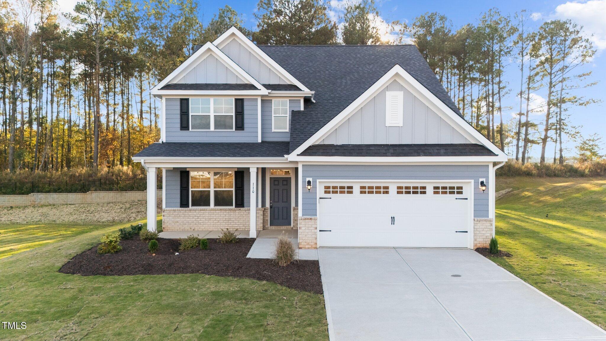 a view of a house with backyard and trees