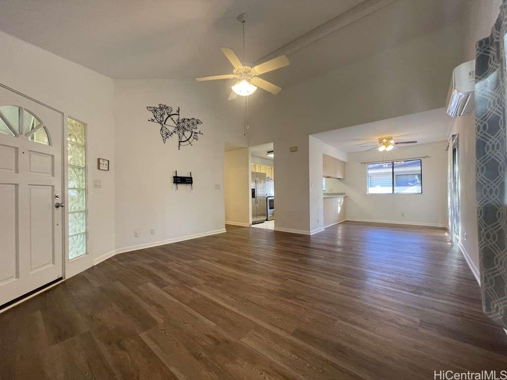 a view of an empty room with window and wooden floor