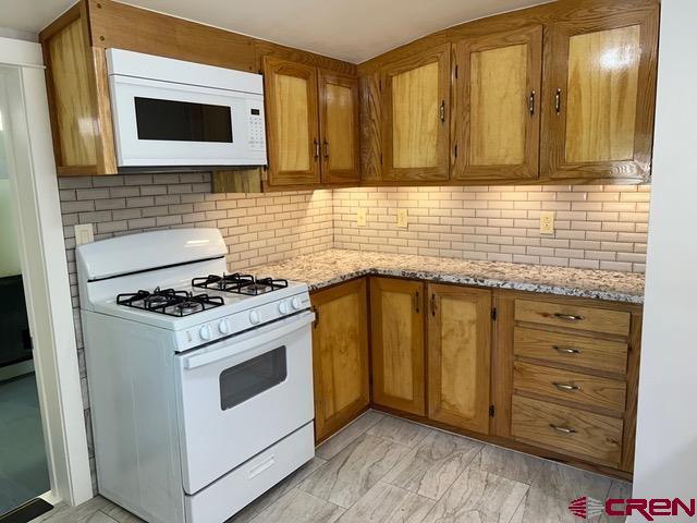 a kitchen with granite countertop cabinets stainless steel appliances and a wooden floor