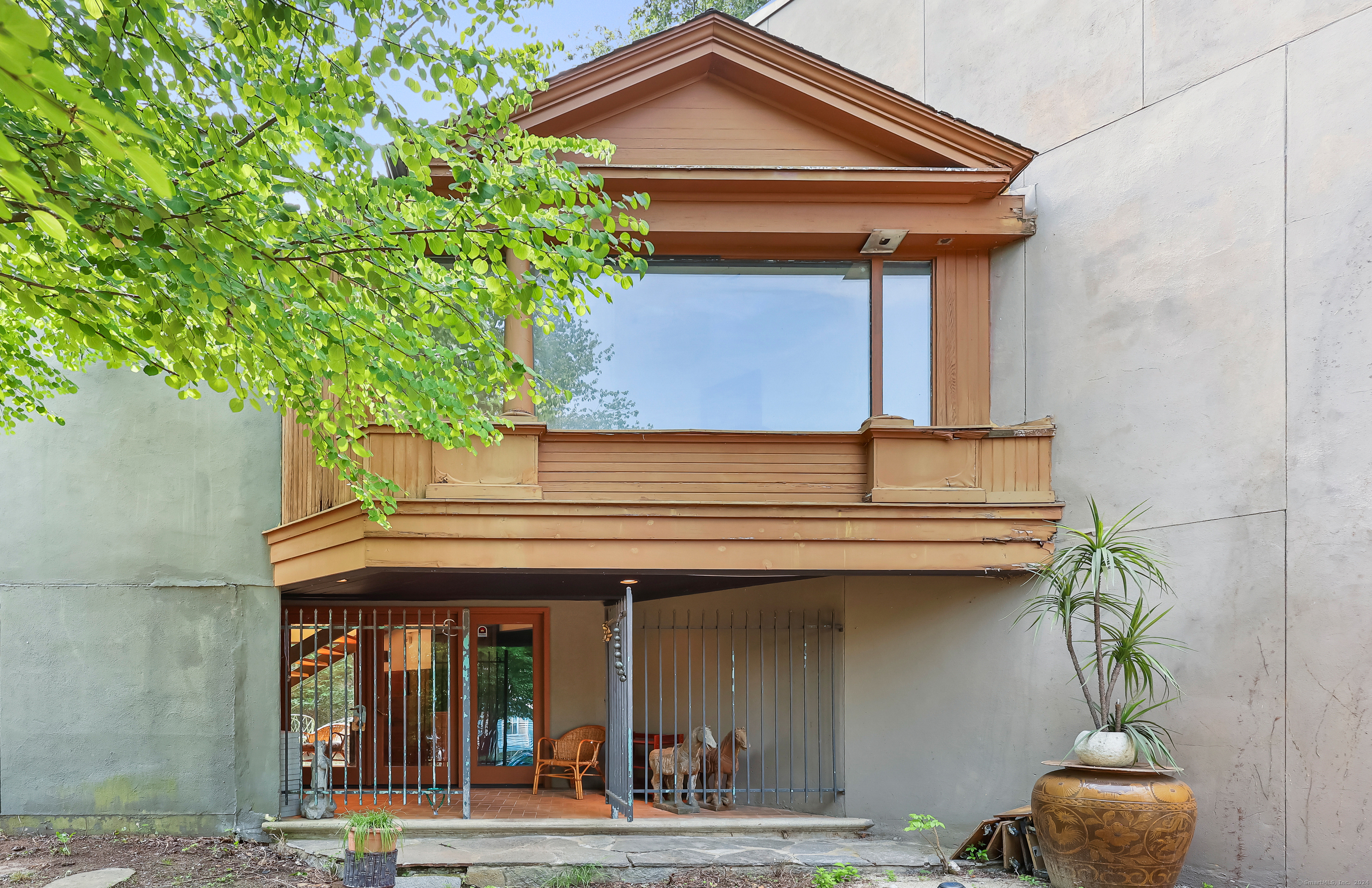 a view of a house with a window and potted plants