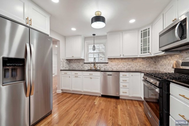 a kitchen with stainless steel appliances granite countertop a refrigerator sink and microwave