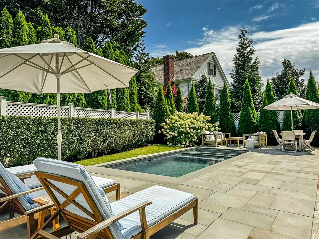 a view of a patio with a table and chairs under an umbrella