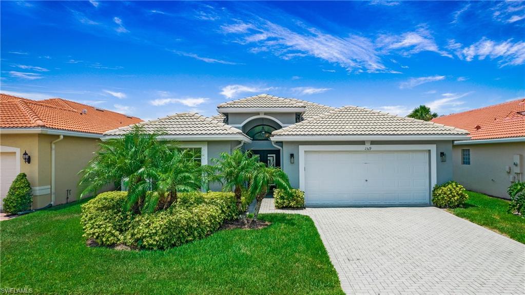 Mediterranean / spanish-style house featuring a garage and a front yard