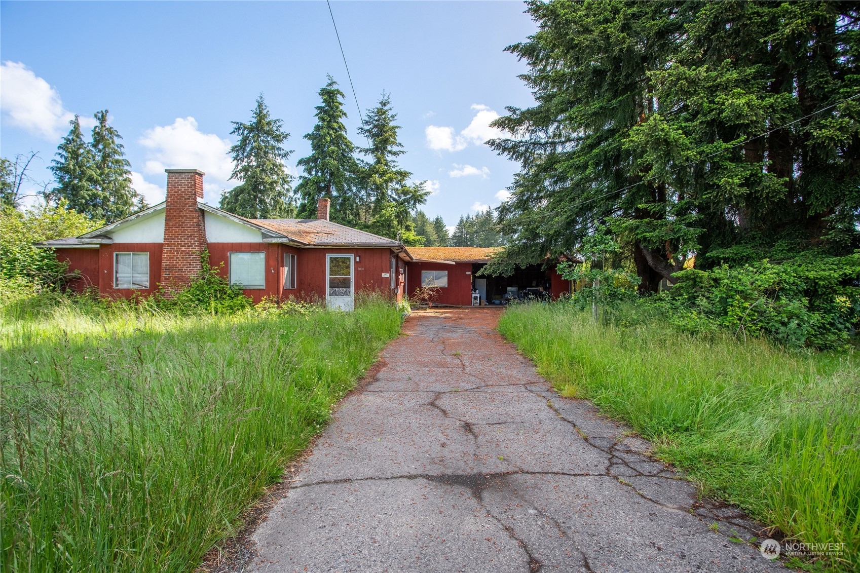 a front view of a house with a yard and trees