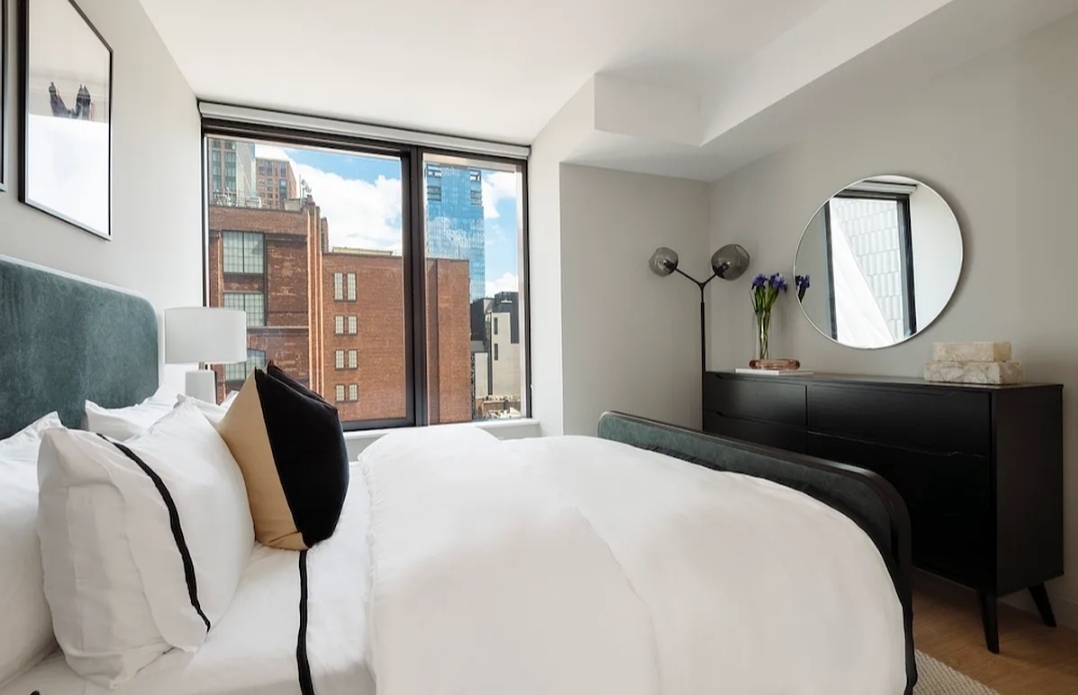 a bedroom with a bed mirror and window