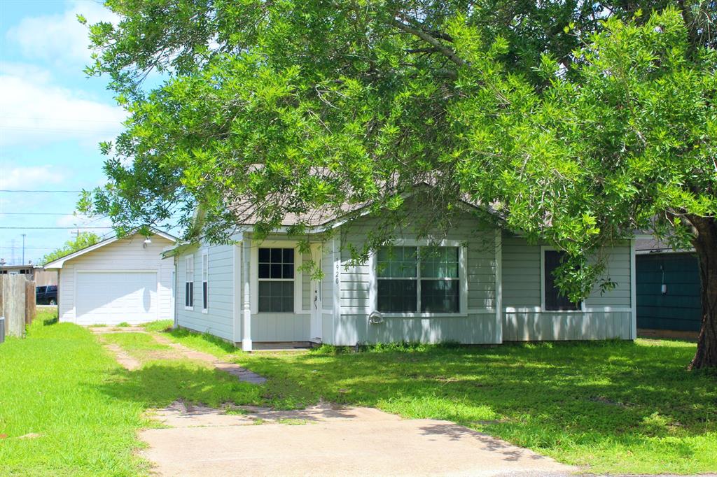 a view of a house with a yard and potted plants