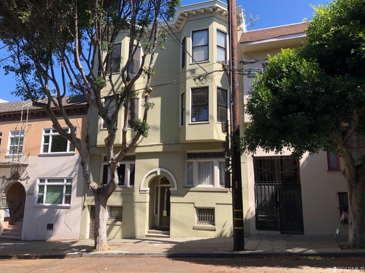 a front view of a residential apartment building with a yard and garage