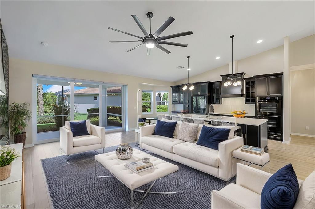 a living room with furniture kitchen view and a large window