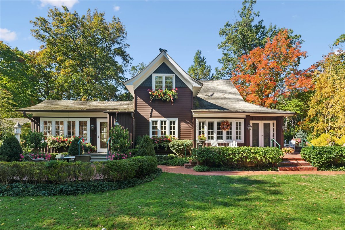 a front view of a house with a yard and potted plants