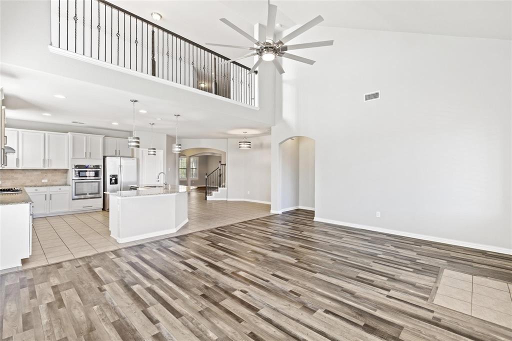 a large white kitchen with kitchen island a stove a sink and a refrigerator