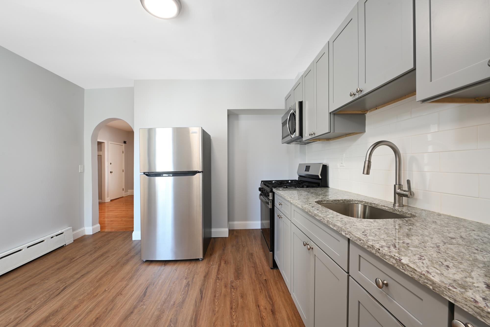 a kitchen with sink a refrigerator and cabinets