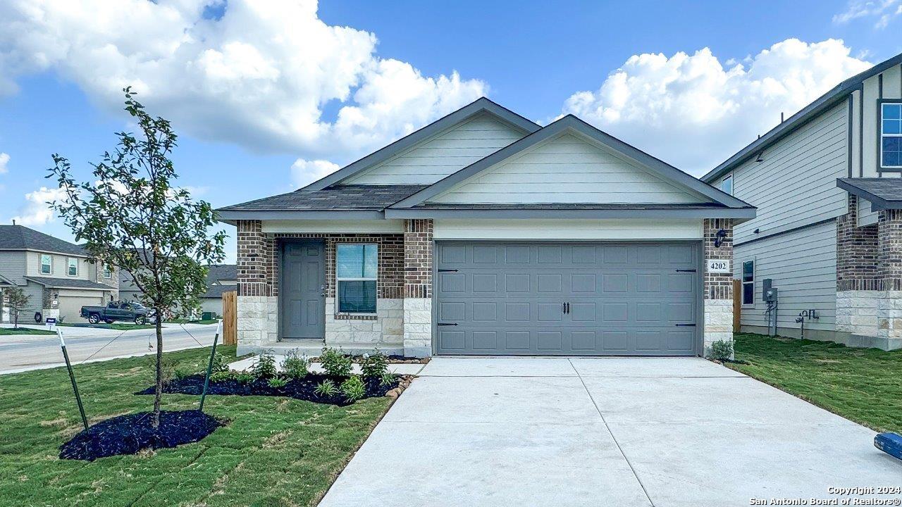 a view of a house with a yard and a garage