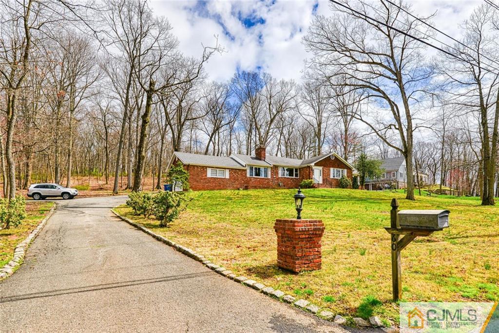 a front view of a house with a yard and tree