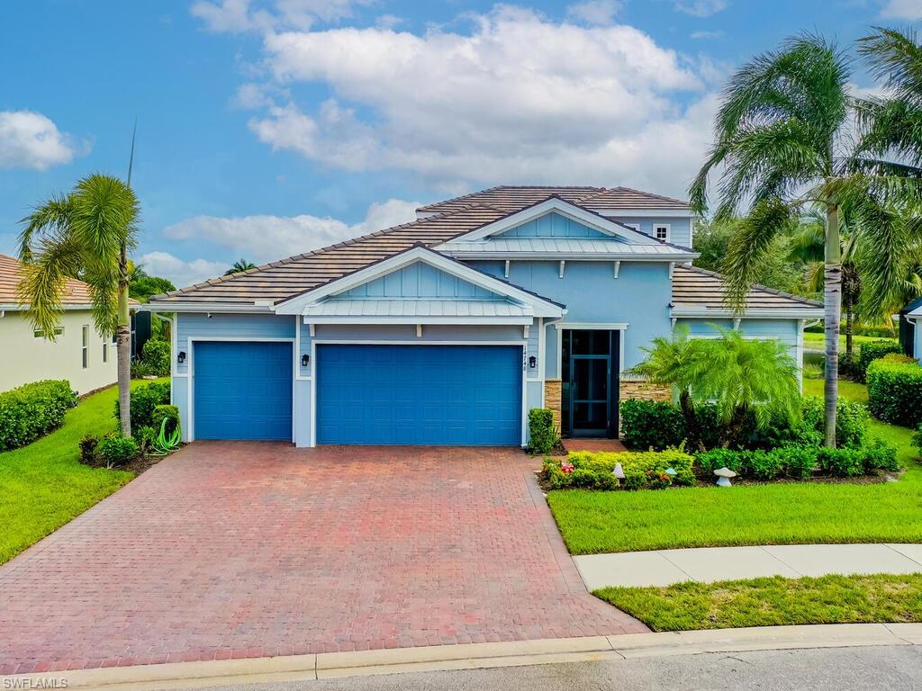 a front view of a house with a yard and potted plants