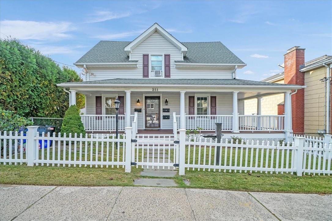 Farmhouse featuring a front yard and covered porch