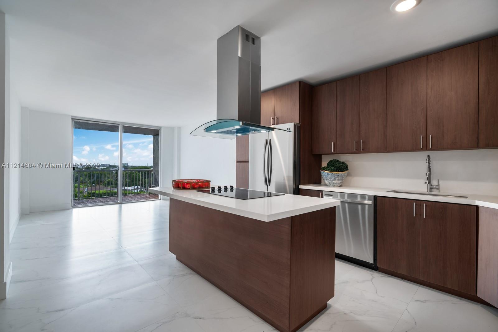 a kitchen with kitchen island a sink counter top space and cabinets