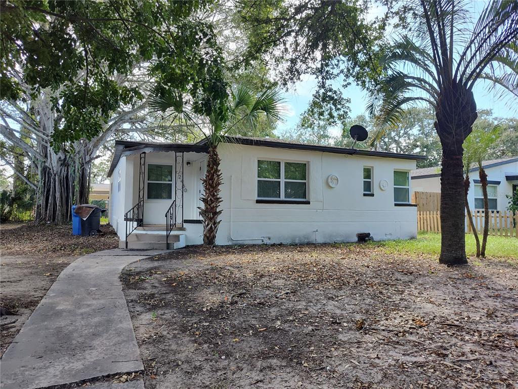 a view of a house with a yard and large tree