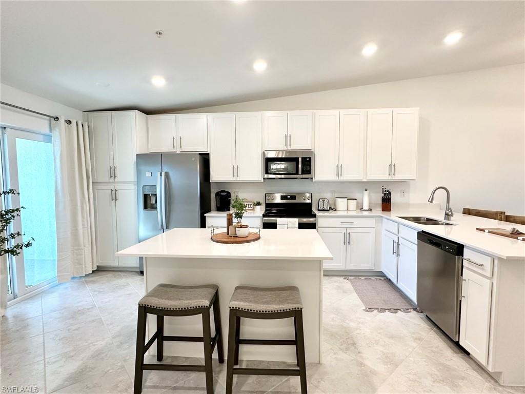 a kitchen with refrigerator a sink and white cabinets