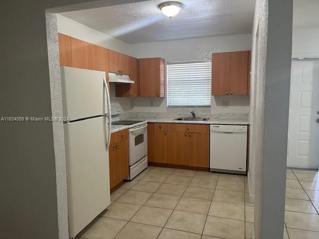 a kitchen with a sink a refrigerator and cabinets