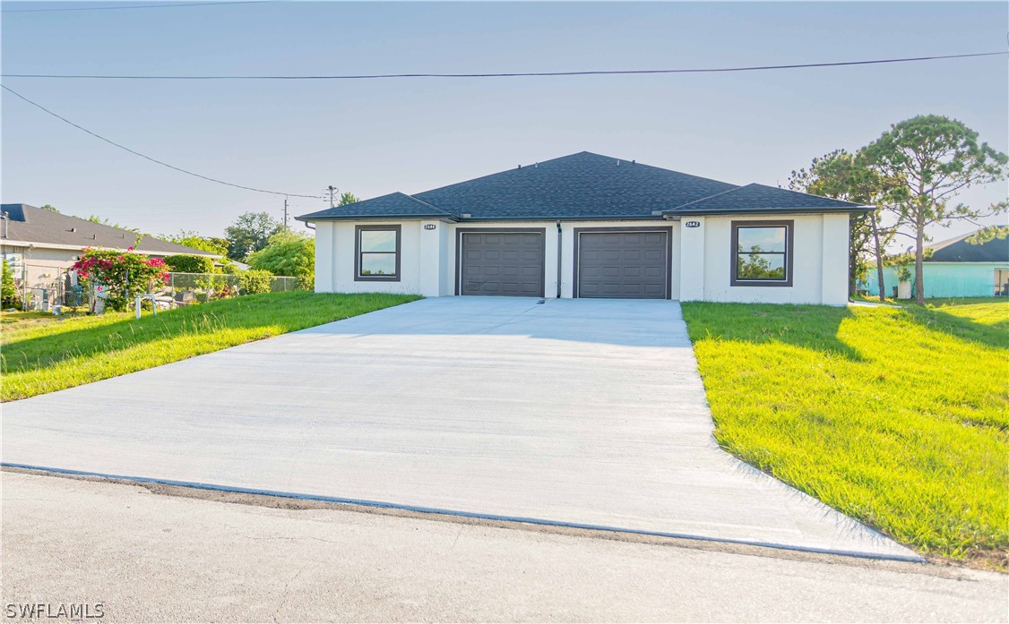 a front view of a house with a yard and garage