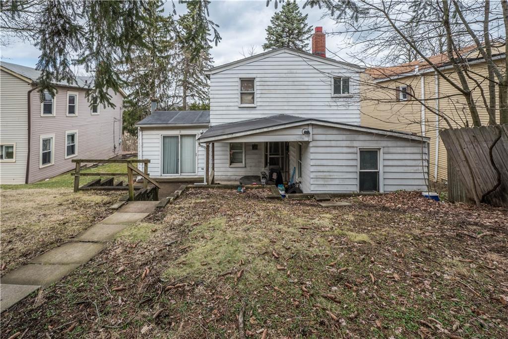 a backyard of a house with barbeque oven and brick wall