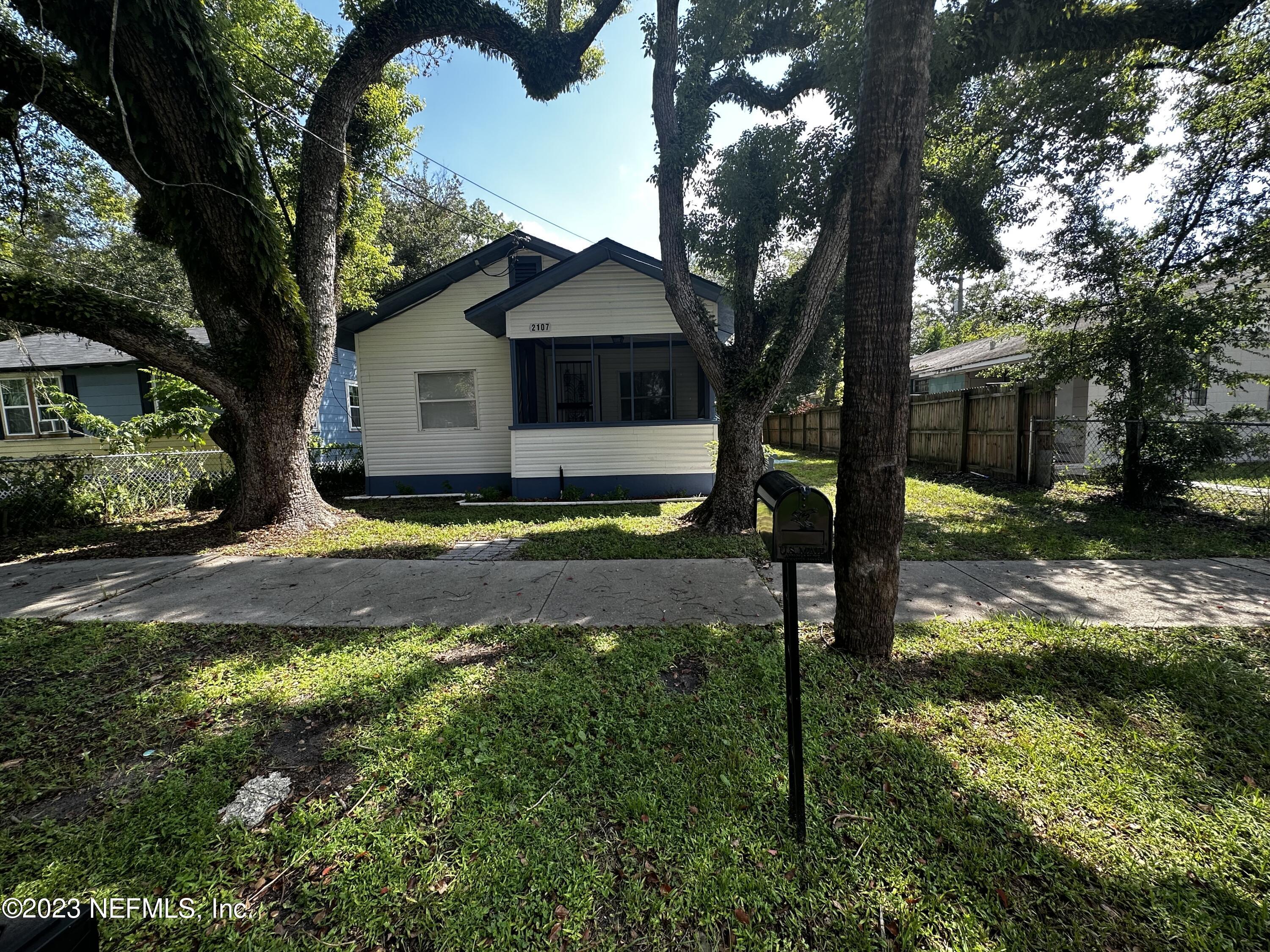 a view of a house with yard and a tree