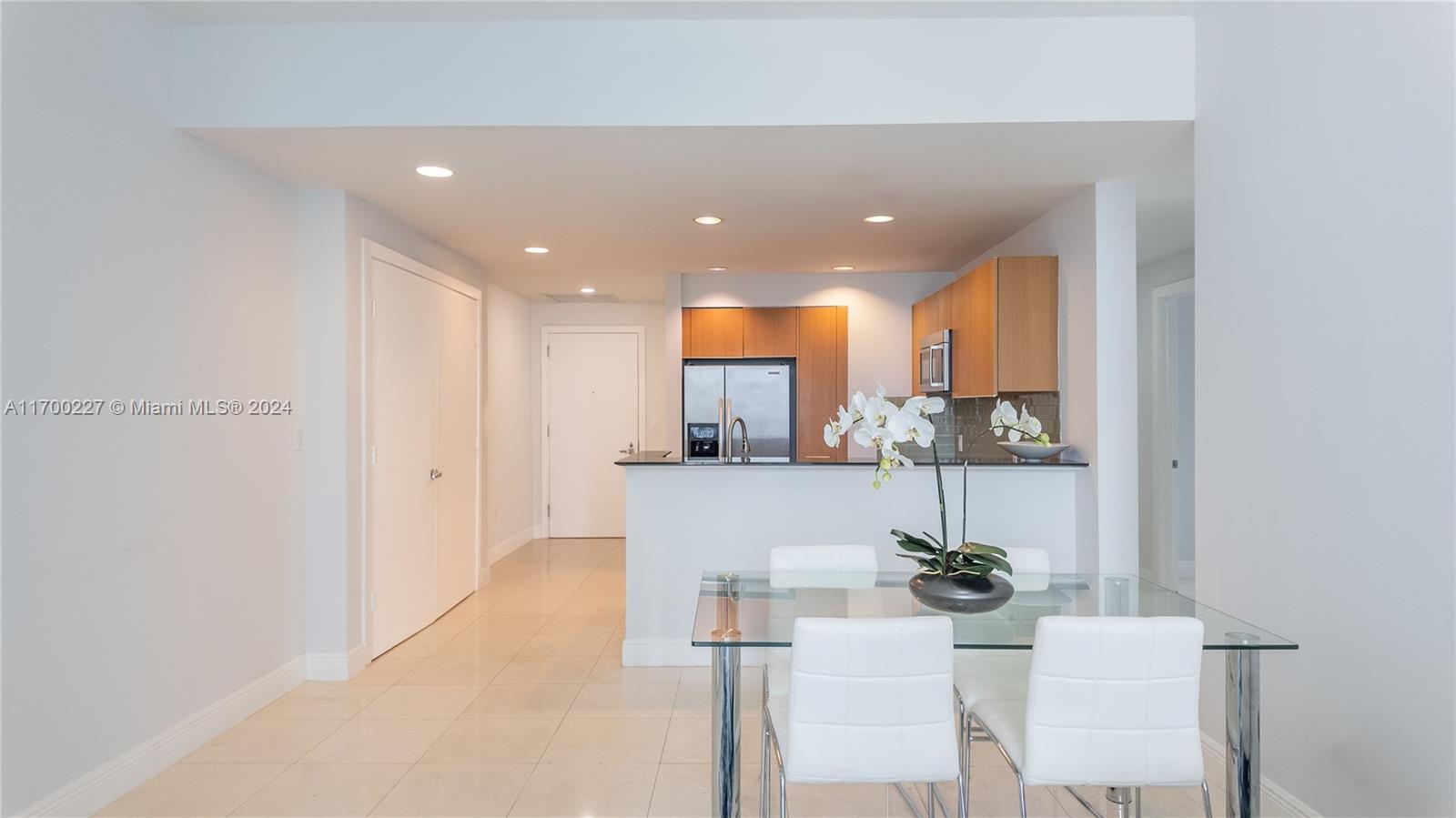 a view of kitchen with stainless steel appliances kitchen island sink and refrigerator