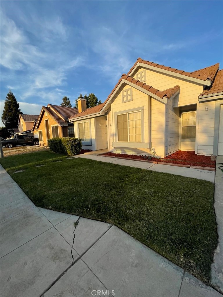 a view of a big house with a big yard and plants