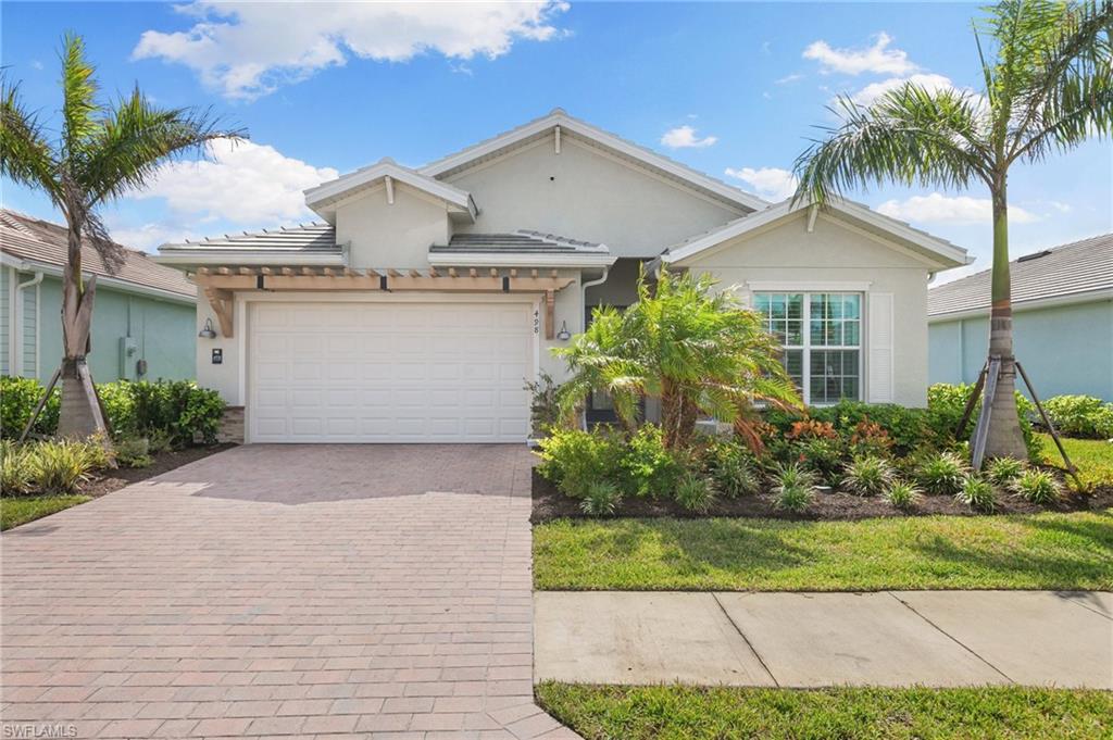 a front view of a house with a garden and palm trees