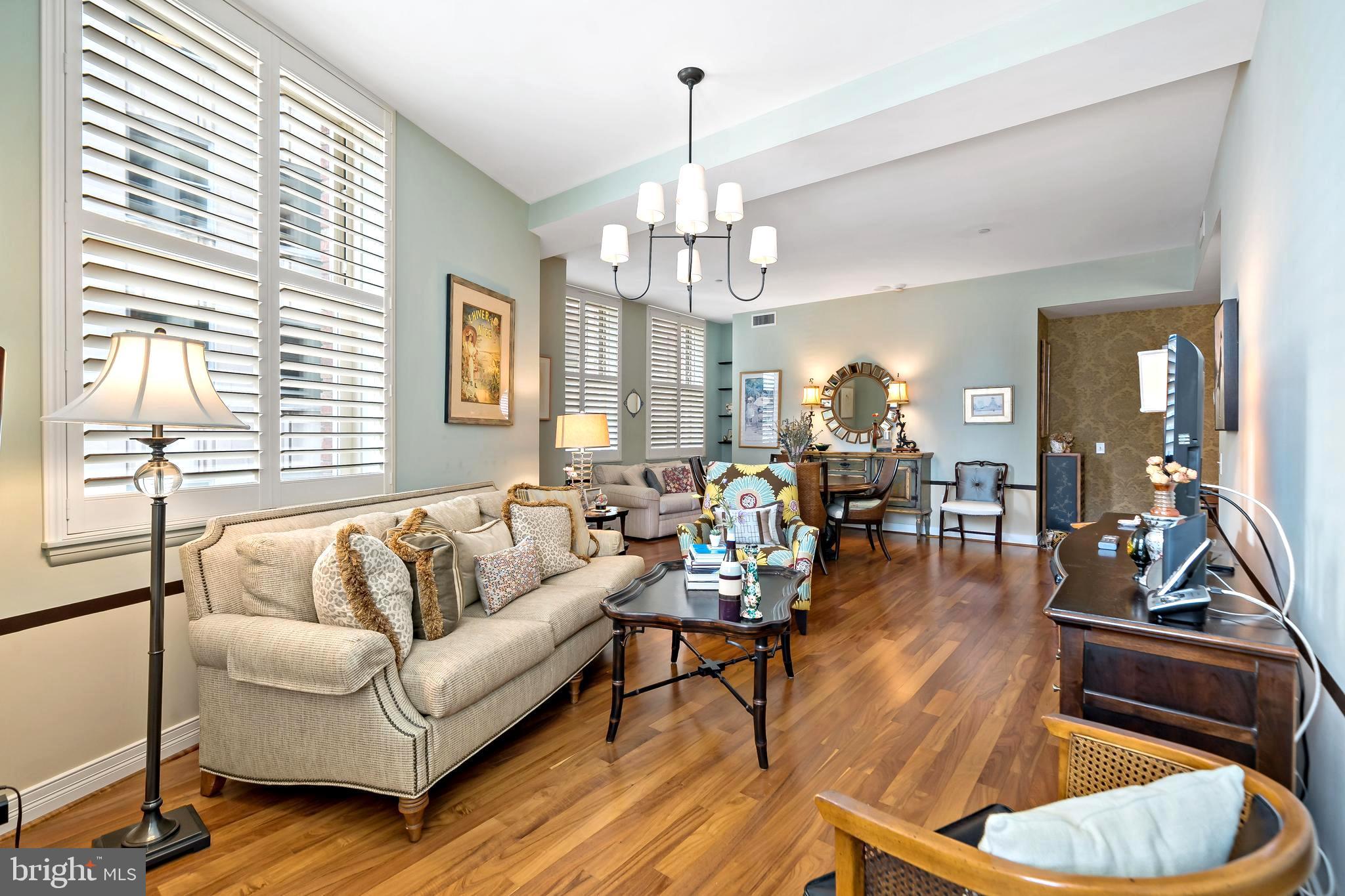 a living room with furniture or chandelier and a wooden floor