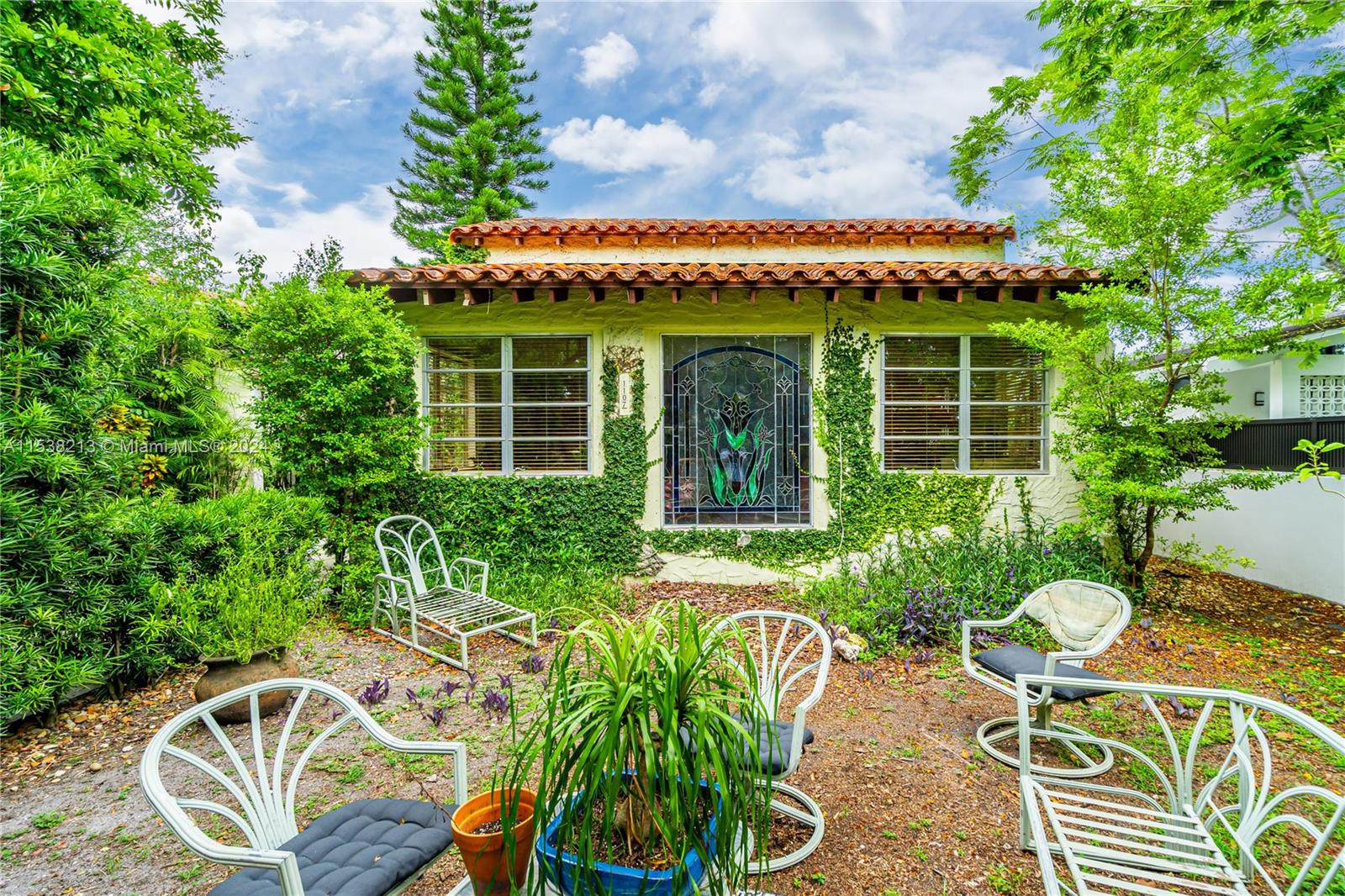 a view of a chairs and table in a back yard