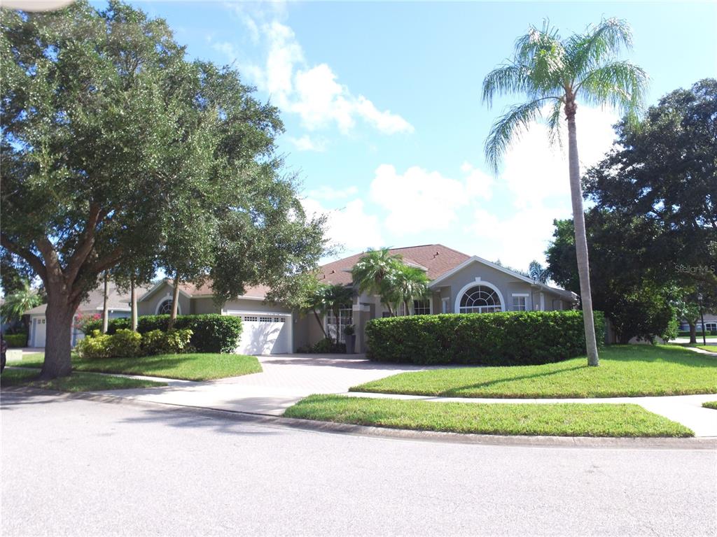 a front view of a house with a yard and palm trees