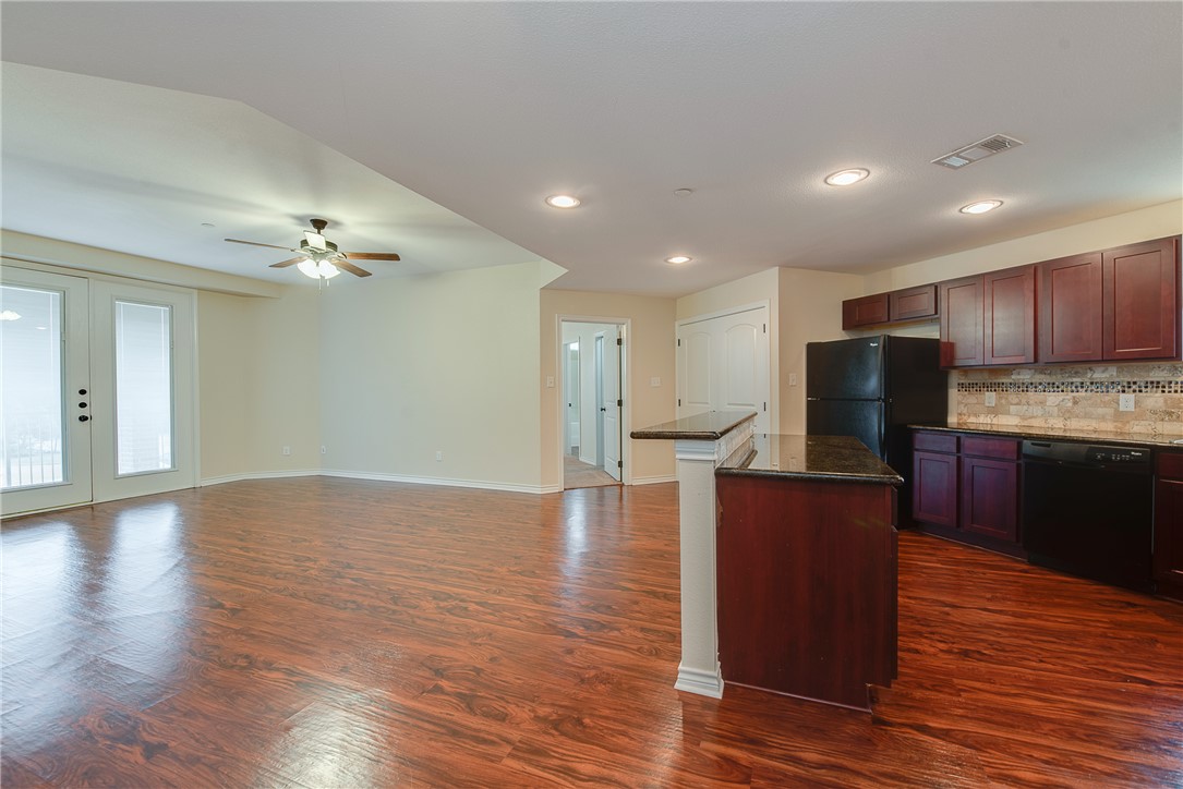 a view of kitchen with kitchen island microwave and wooden floor