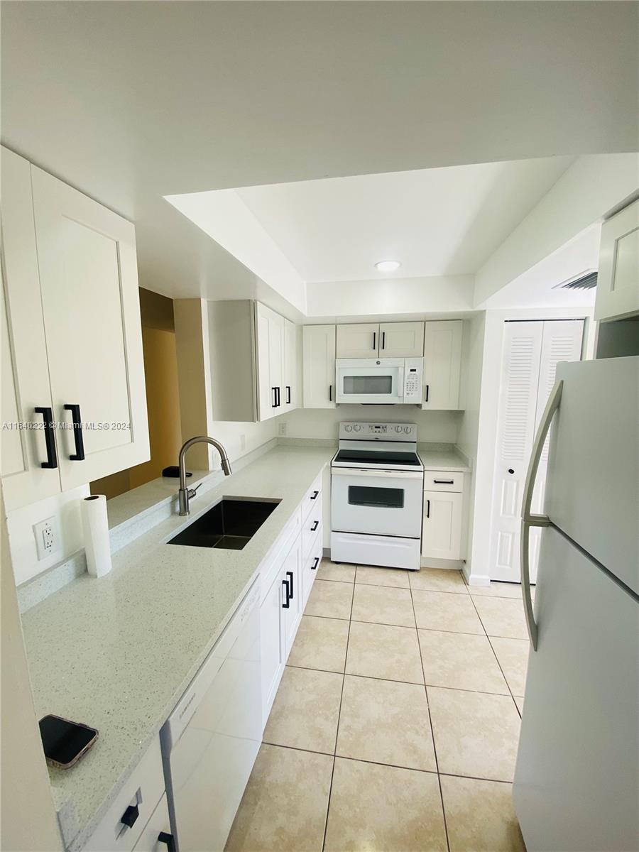 a kitchen with a sink a stove top oven and refrigerator