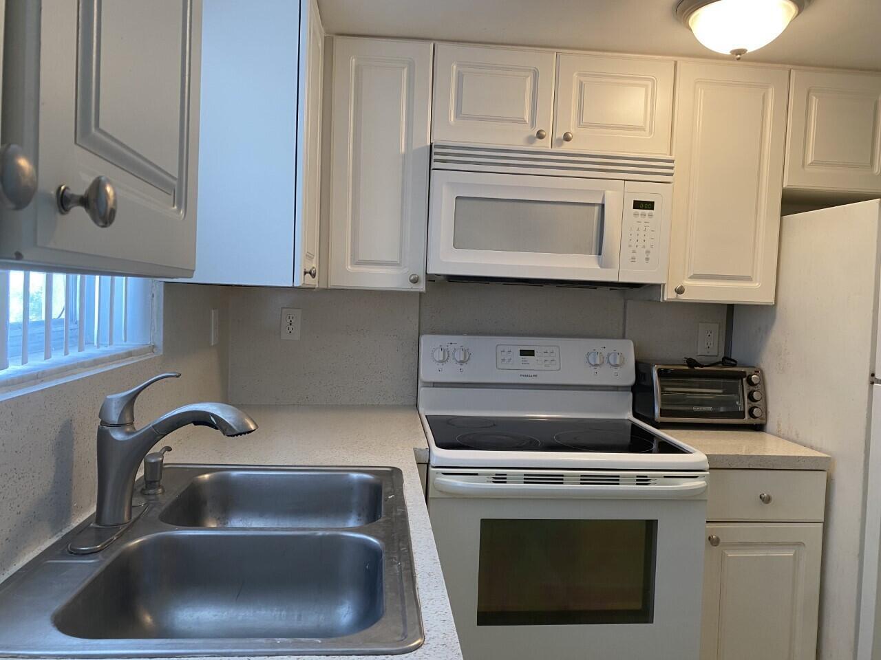 a kitchen with white cabinets and a stove top oven