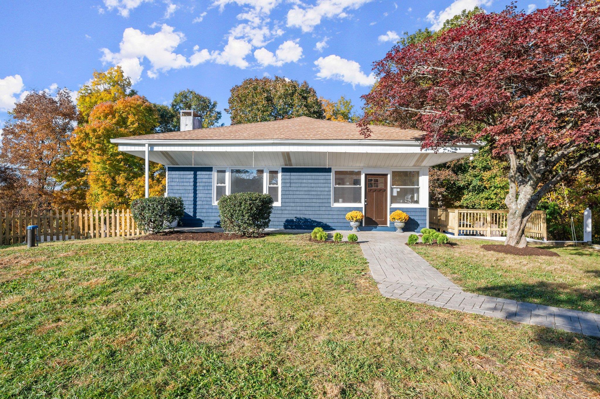 a front view of a house with a yard and potted plants