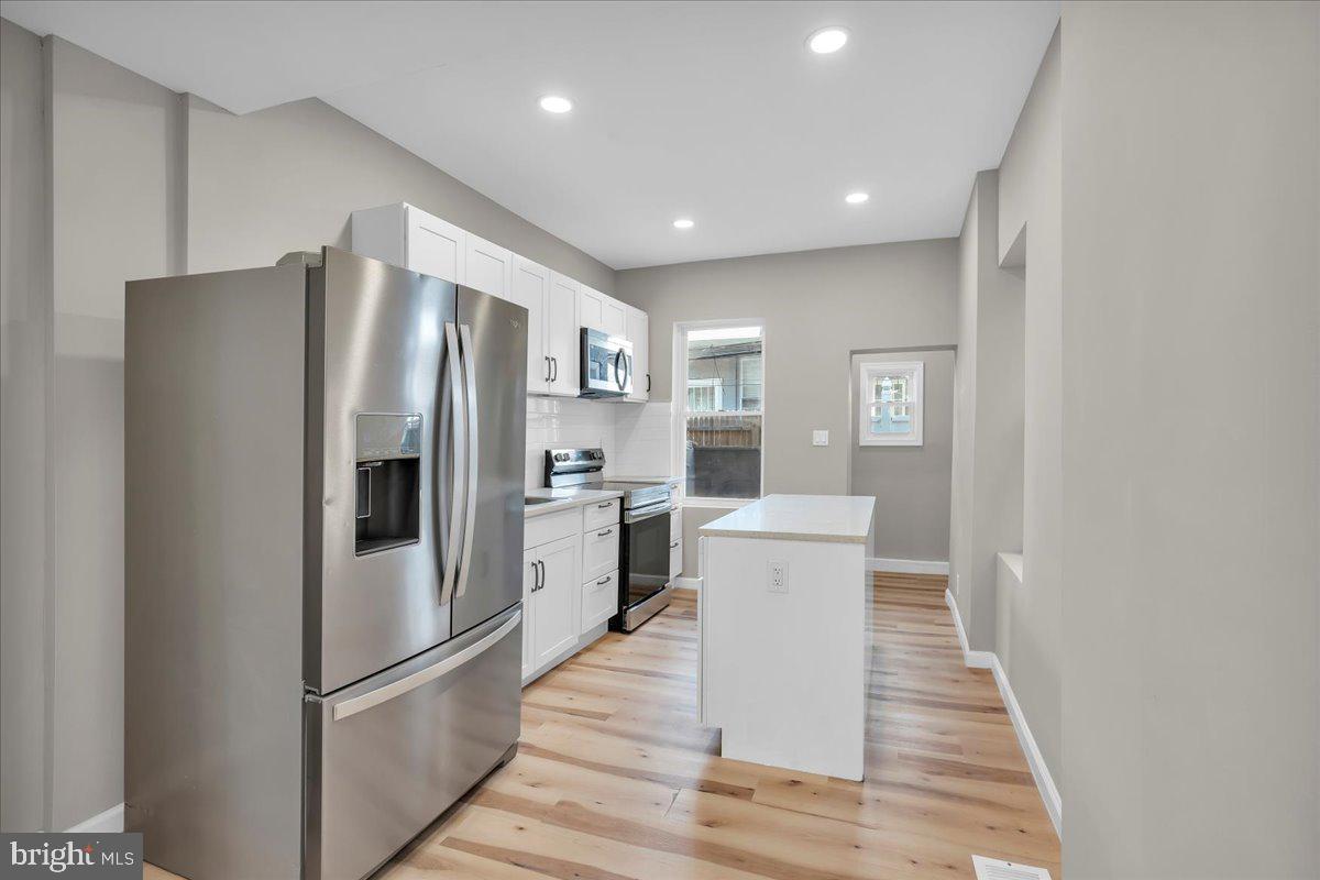 a kitchen with a refrigerator a sink and cabinets