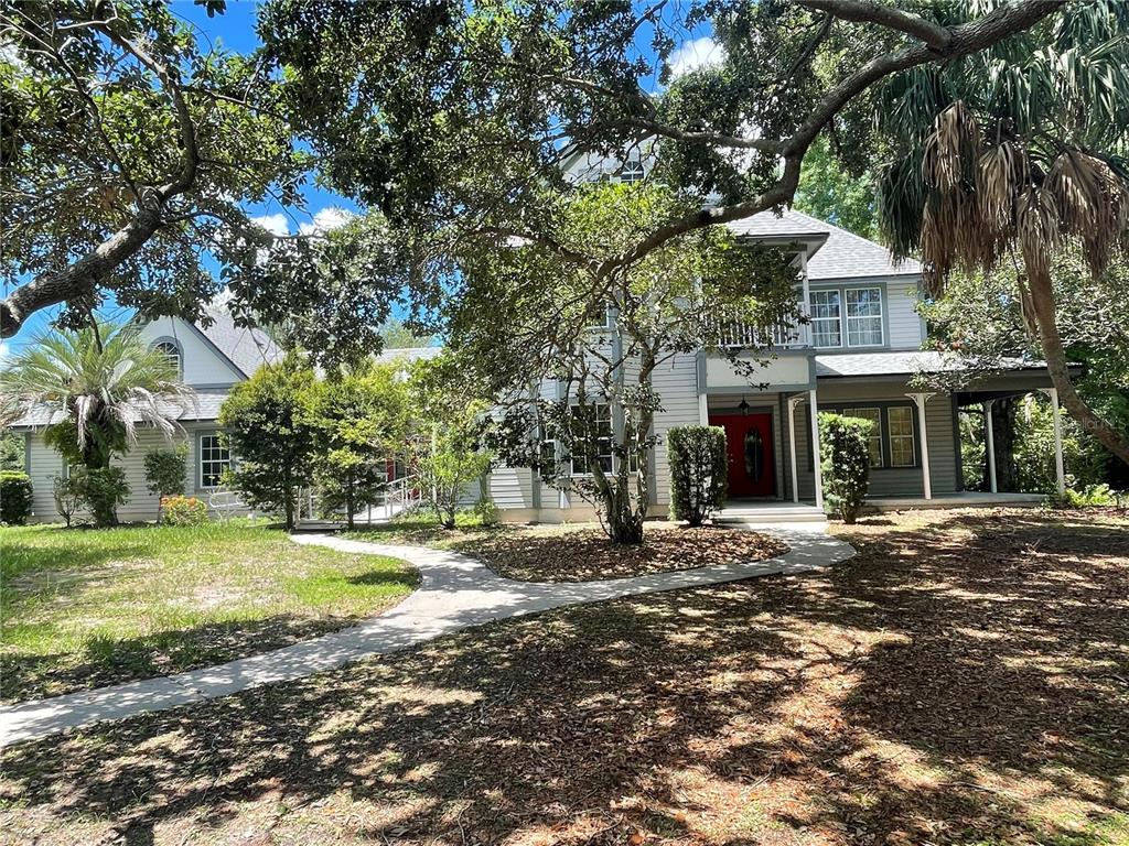 a front view of a house with a yard and trees