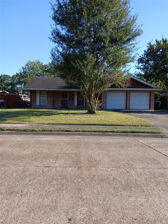 a view of a house with a yard and large trees