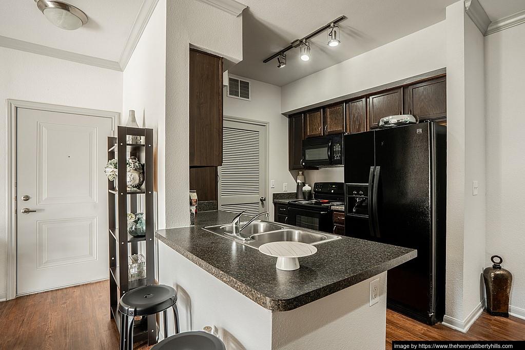 a kitchen with stainless steel appliances granite countertop a sink refrigerator and cabinets