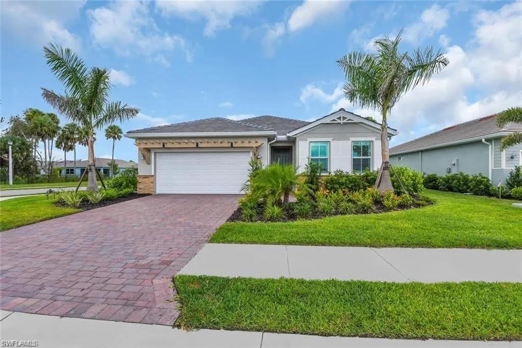 a front view of a house with a garden and palm trees