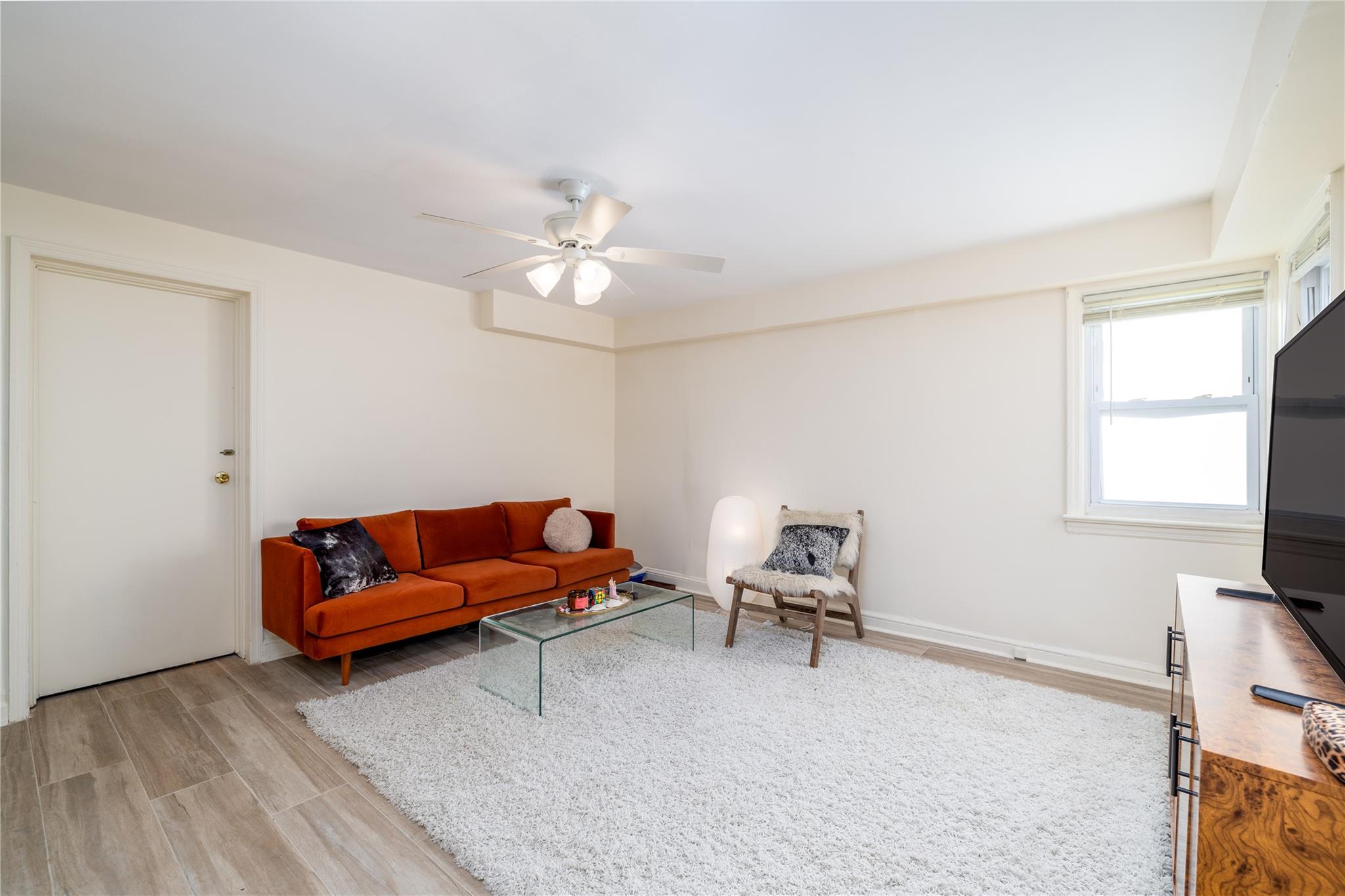 Living room with ceiling fan and light wood-type flooring