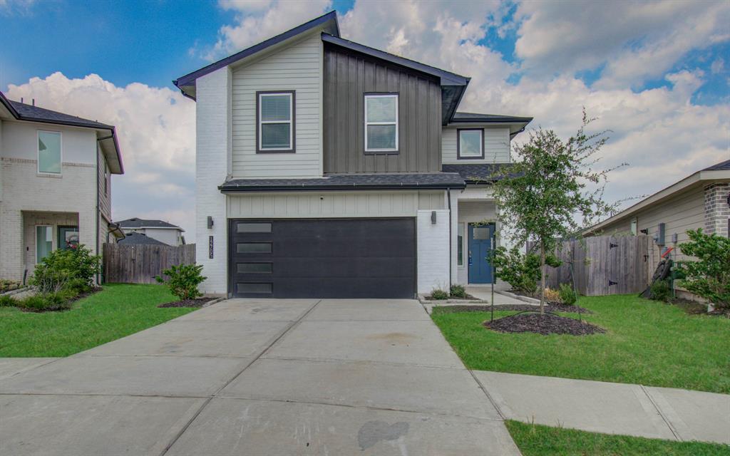 a front view of a house with a garden and garage