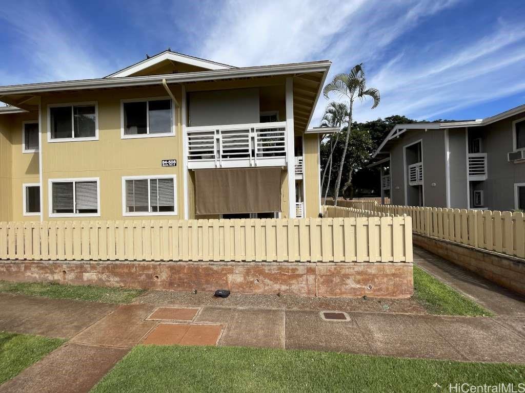 a view of a house with a small yard and wooden fence